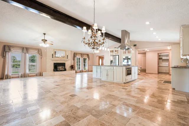 a large kitchen with stainless steel appliances kitchen island granite countertop a sink and cabinets