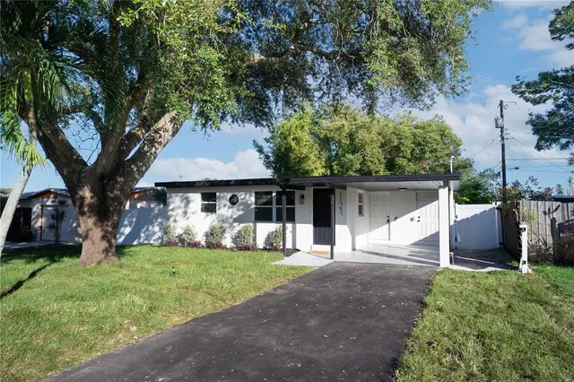 a front view of a house with a yard and trees