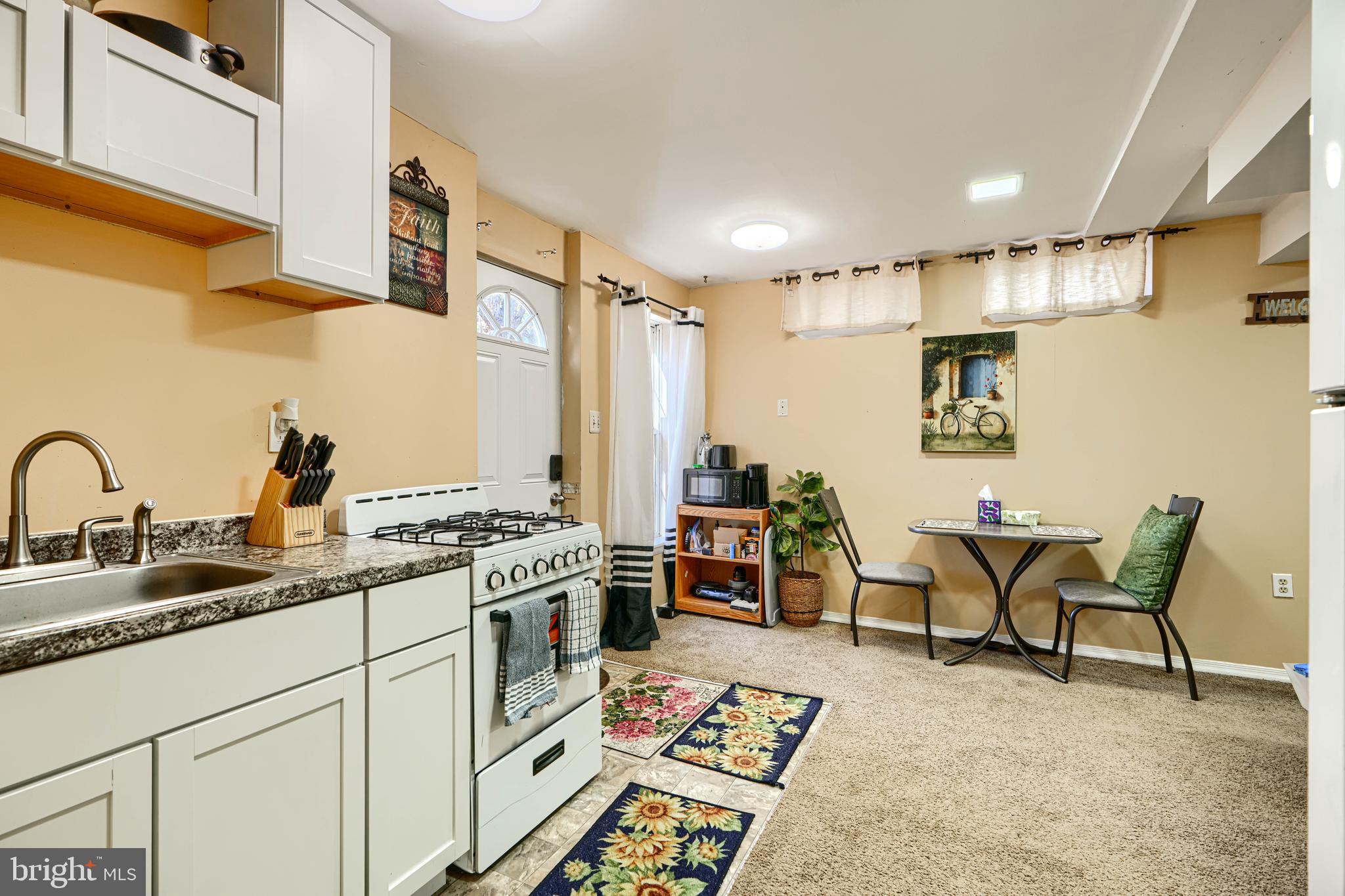 4 High Side Court Owings Mills, MD 21117 - Photo 25 of 30 a open kitchen with stainless steel appliances granite countertop a stove a sink dishwasher and white cabinets with wooden floor