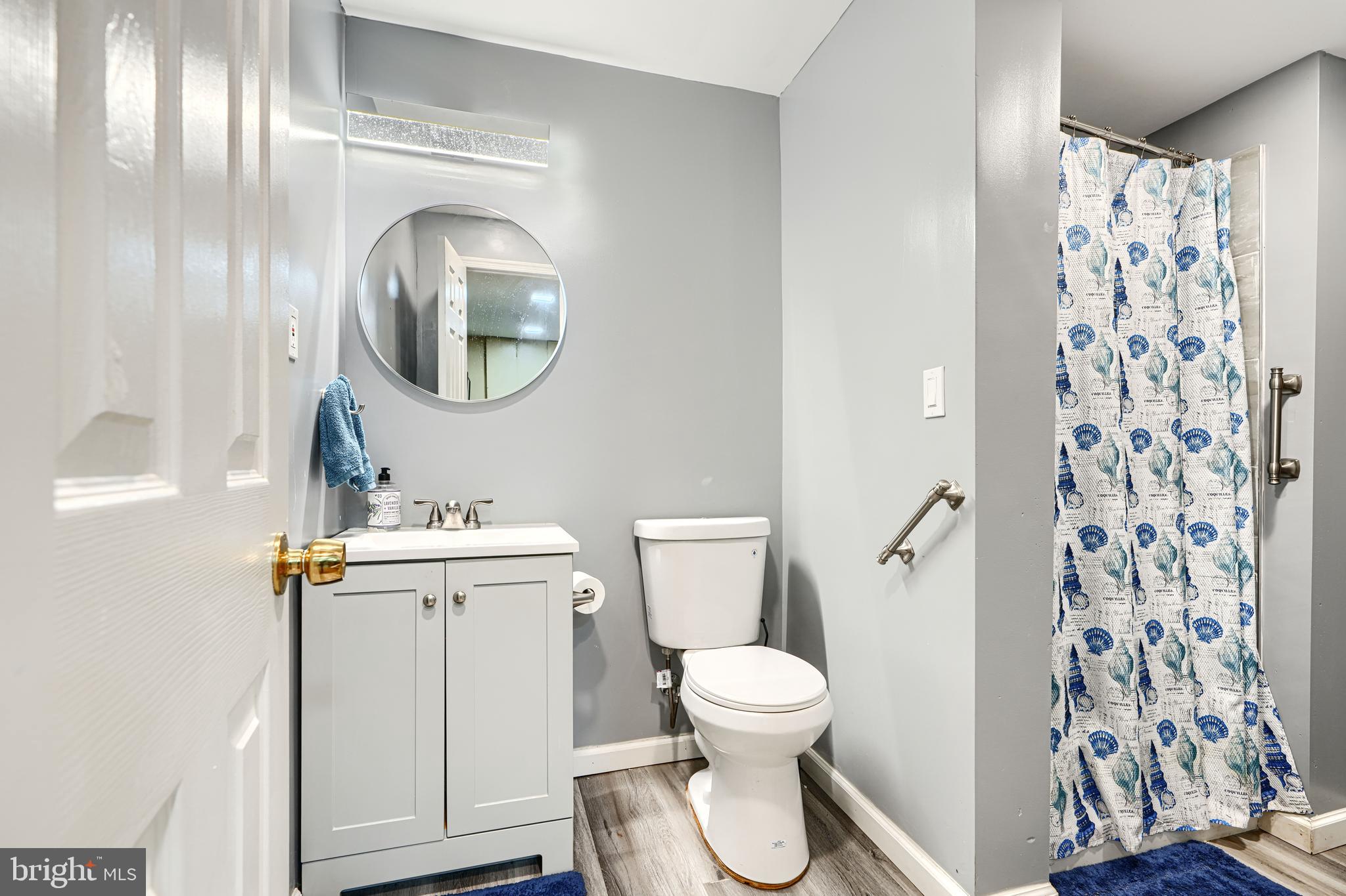 4 High Side Court Owings Mills, MD 21117 - Photo 27 of 30 a white toilet sitting next to a bathroom sink and a mirror