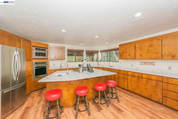 a large kitchen with stainless steel appliances granite countertop a sink and cabinets