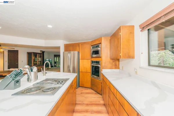 a large kitchen with sink a counter top space and stainless steel appliances