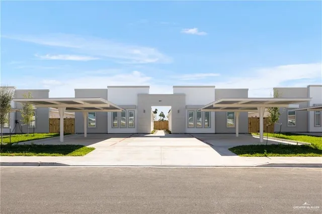 a front view of residential houses with yard and car parked