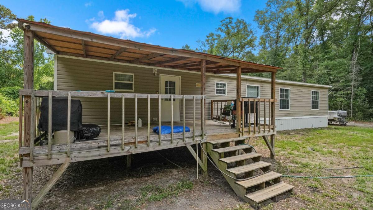 64 Sierra Road Jesup, GA 31545 - Photo 4 of 22 a front view of a house with a garden and patio
