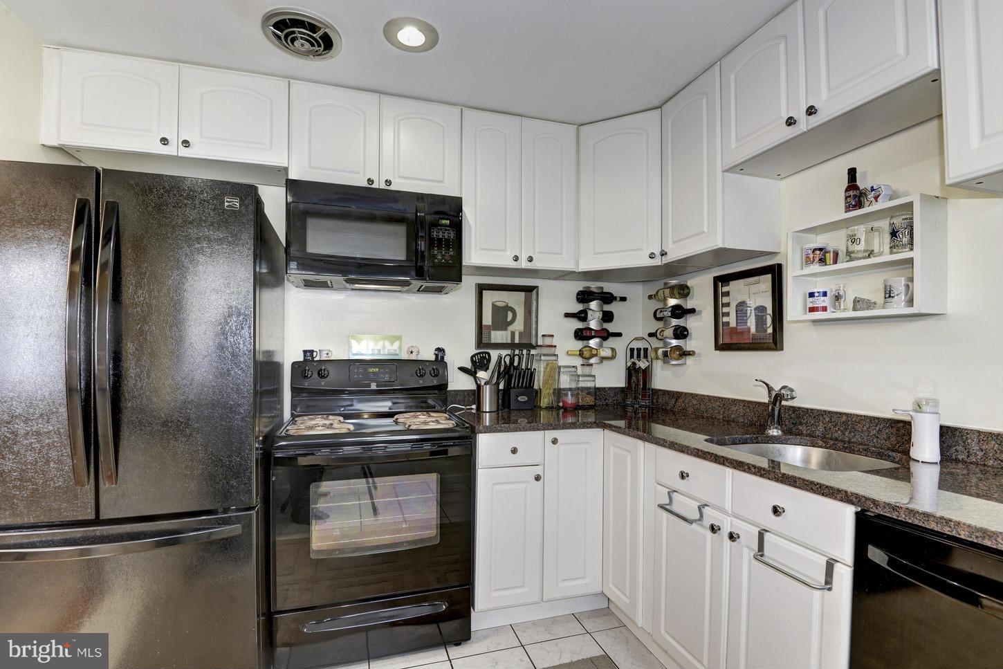 6203 Apache Street Springfield, VA 22150 - Photo 9 of 22 a kitchen with granite countertop a sink stove and refrigerator