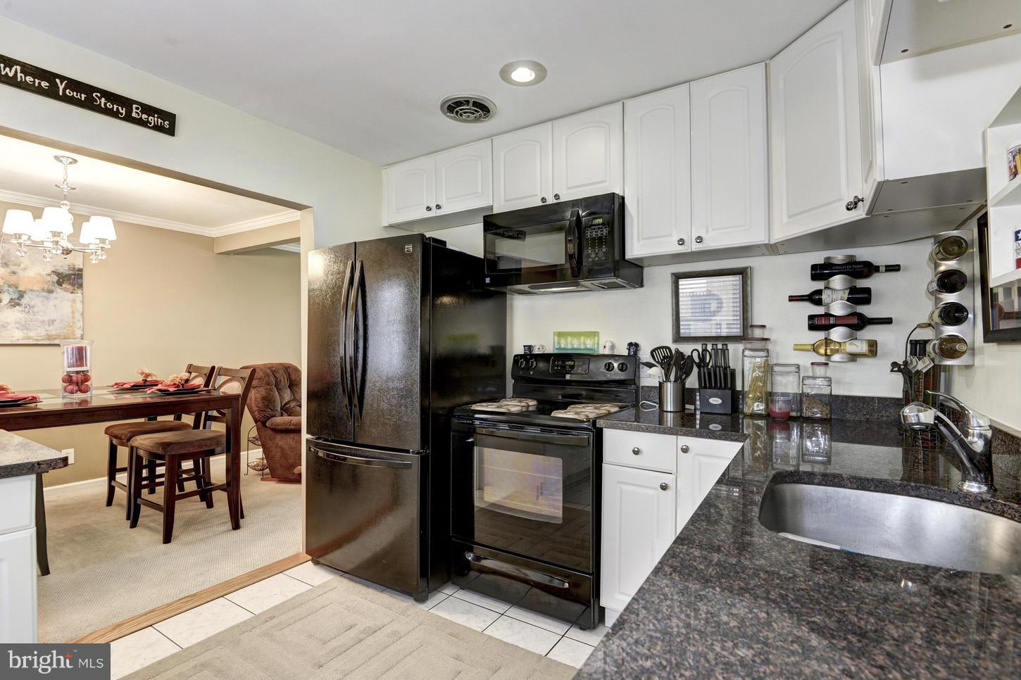 6203 Apache Street Springfield, VA 22150 - Photo 10 of 22 a kitchen with stainless steel appliances granite countertop a refrigerator a stove a sink a dining table and chairs