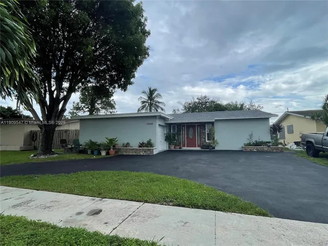 front view of a house with a yard and potted plants