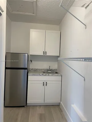 a kitchen with a white cabinets and refrigerator