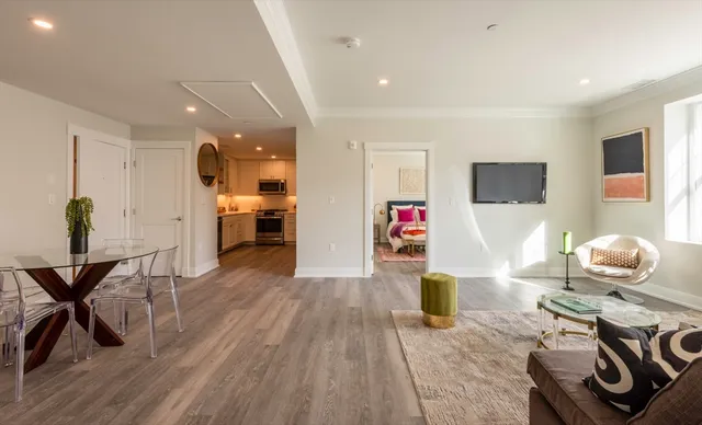 a living room with furniture and a wooden floor