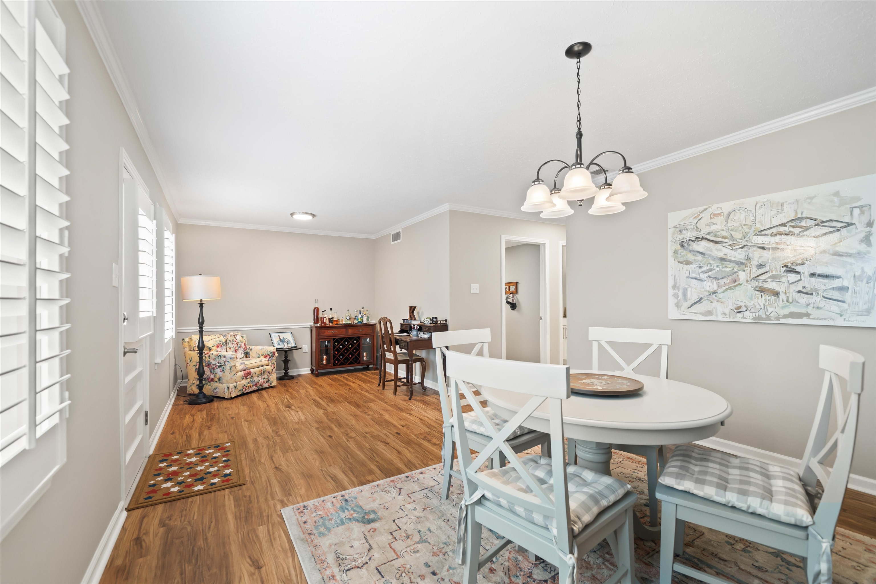 6943 Fords Station Road, Unit 64 Germantown, TN 38138 - Photo 12 of 30 Open concept living and dining area featuring wood-finish flooring, plantation shutters, and a chandelier with frosted glass shades