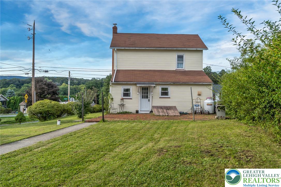 506 Richmond Road Bangor, PA 18013 - Photo 39 of 43 A spacious grassy yard sits behind this classic multi-level residence under clear blue skies.