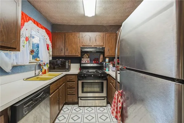 a kitchen with stainless steel appliances granite countertop a sink stove and cabinets