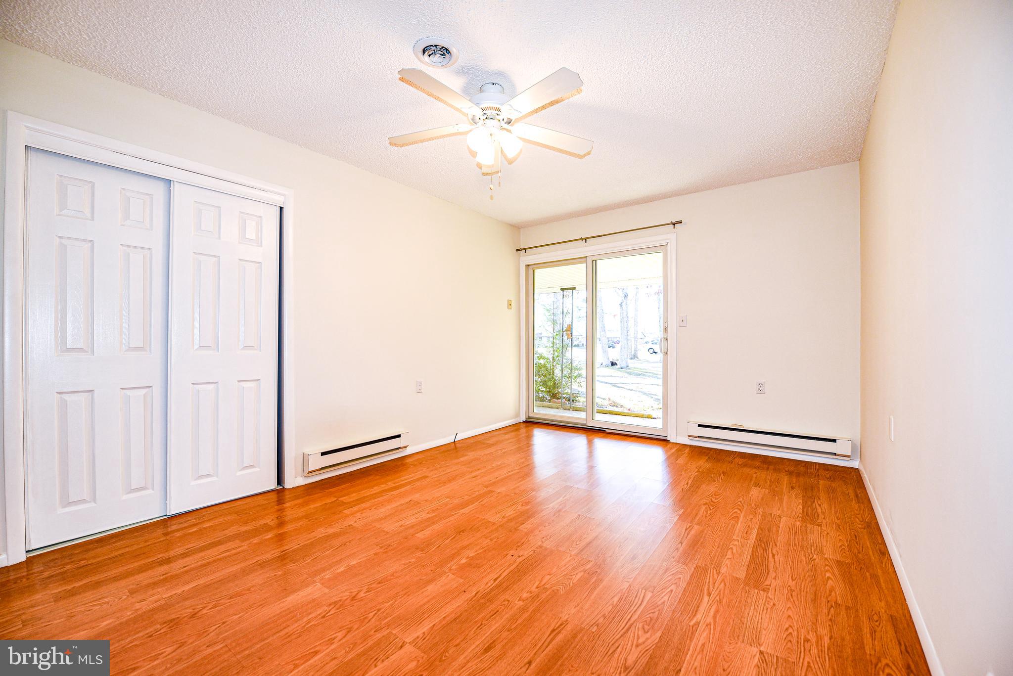 18 B Acorn Road Manahawkin, NJ 08050 - Photo 11 of 19 an empty room with wooden floor chandelier fan and windows