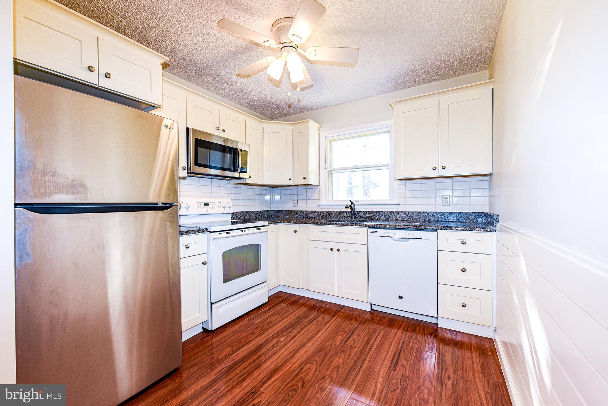 18 B Acorn Road Manahawkin, NJ 08050 - Photo 8 of 19 a kitchen with granite countertop white cabinets and white appliances
