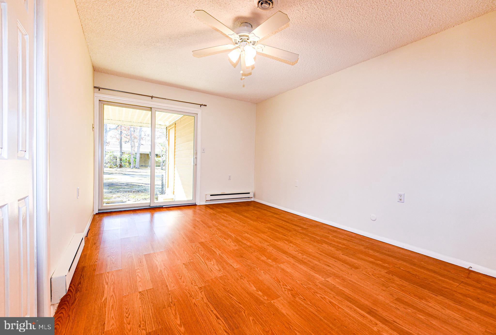 18 B Acorn Road Manahawkin, NJ 08050 - Photo 10 of 19 an empty room with wooden floor and windows