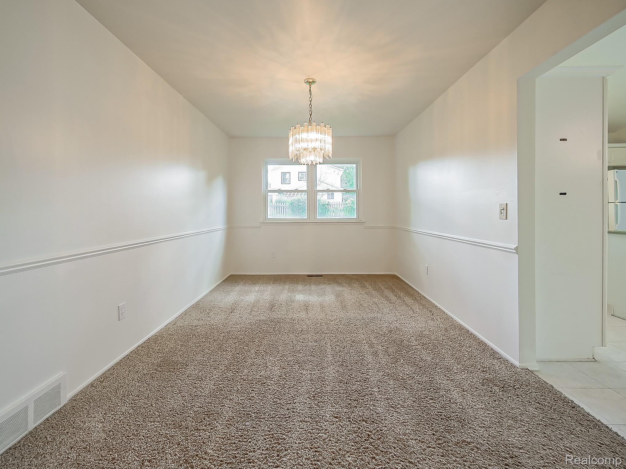 42195 Park Ridge Road Novi, MI 48375 - Photo 8 of 52 Windowed room featuring wall trim, neutral-toned carpeting, and a decorative ceiling light fixture