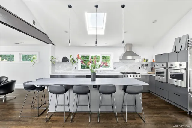 a kitchen with stainless steel appliances kitchen island granite countertop a sink a stove a dining table and chairs