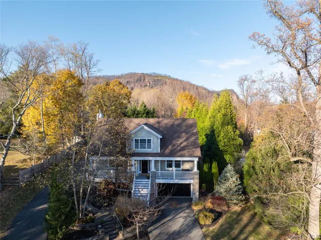 a front view of a house with a yard and mountain view in back