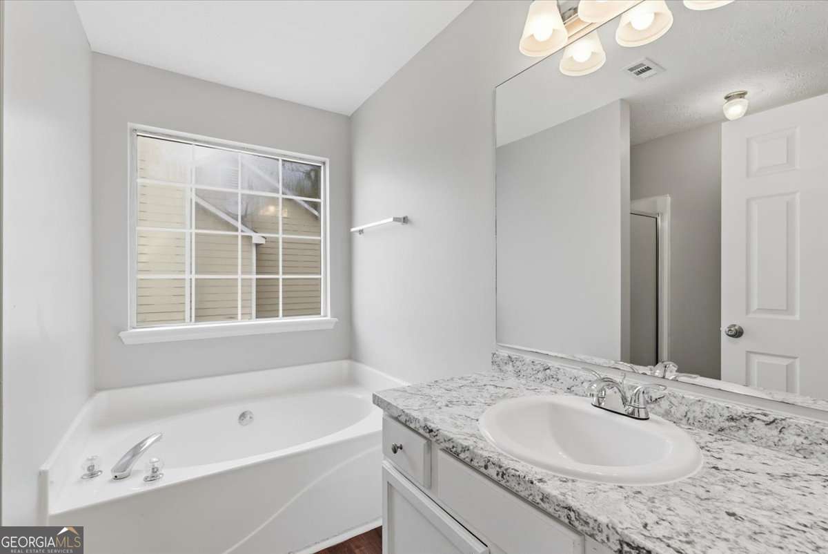 4634 Noah Valley Acworth, GA 30101 - Photo 15 of 27 a bathroom with a granite countertop sink mirror and a bathtub