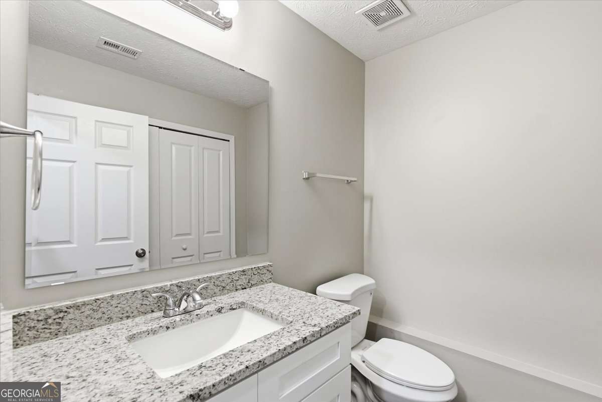 4634 Noah Valley Acworth, GA 30101 - Photo 21 of 27 a bathroom with a granite countertop sink mirror vanity and toilet