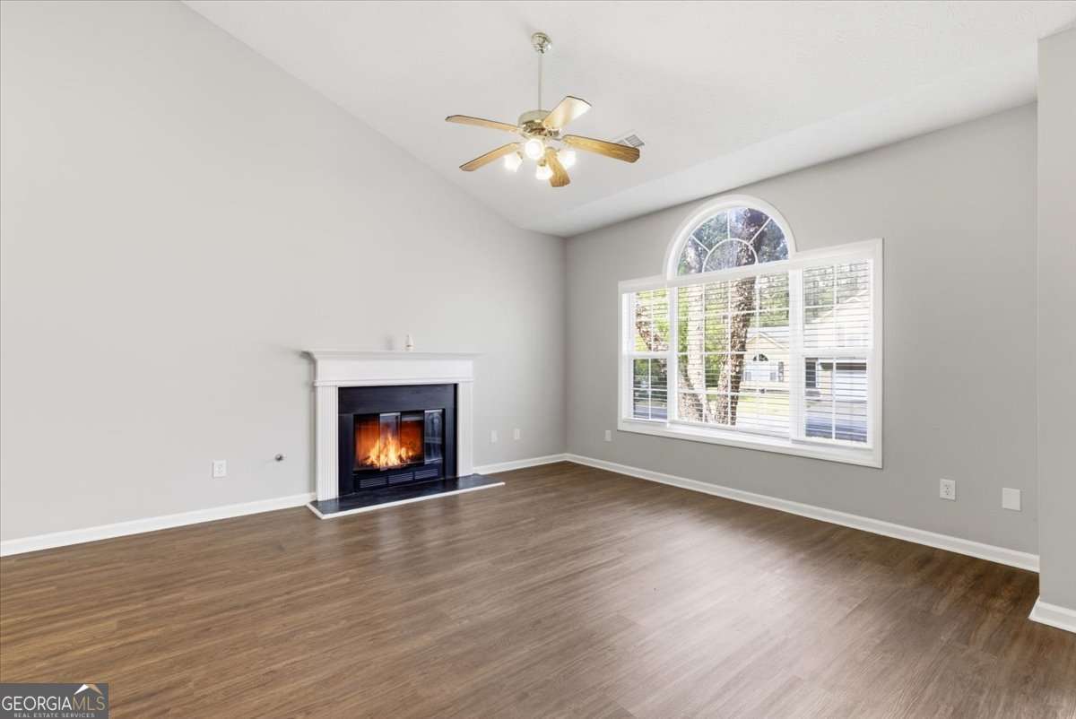 4634 Noah Valley Acworth, GA 30101 - Photo 4 of 27 an empty room with windows fireplace and wooden floor