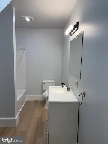 a bathroom with a sink a toilet and mirror