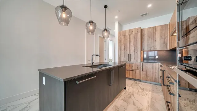 a kitchen with stainless steel appliances granite countertop a sink a stove and a refrigerator