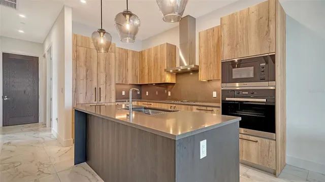 a kitchen with stainless steel appliances granite countertop a sink a stove and a refrigerator