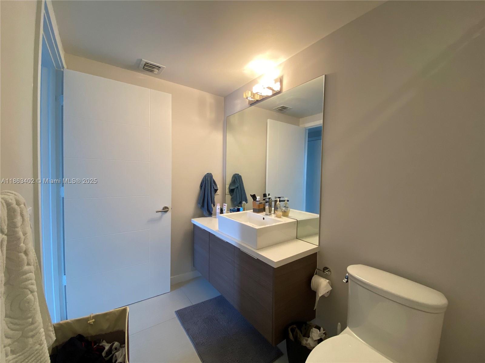 1010 Southwest 2nd Avenue, Unit 1110 Miami, FL 33130 - Photo 12 of 18 a bathroom with a toilet sink and mirror