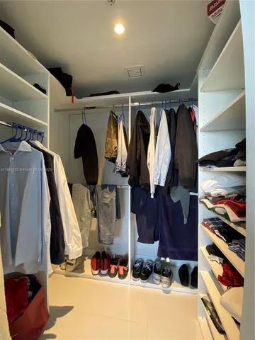 a view of walk in closet with clothes and shoes