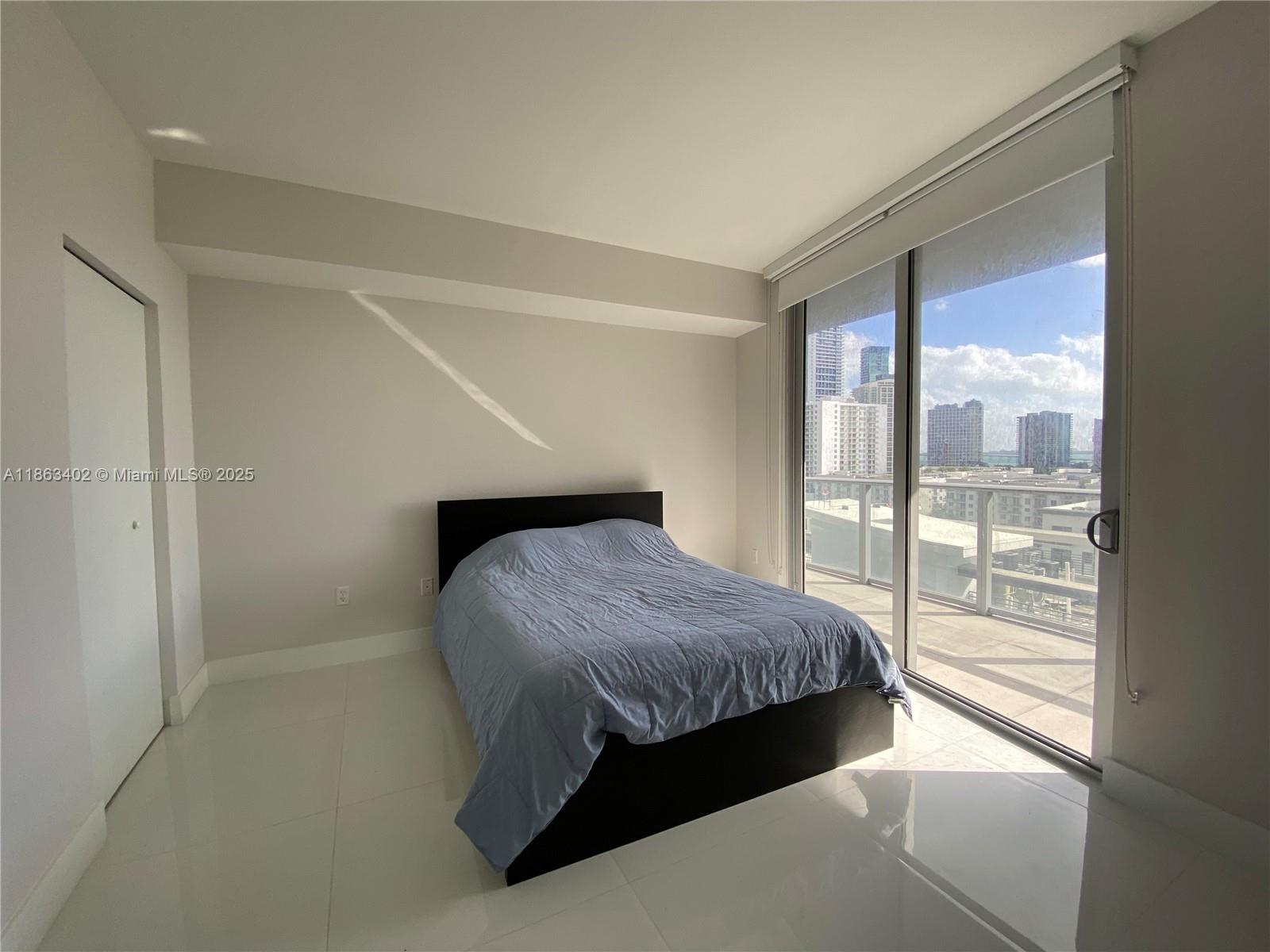 1010 Southwest 2nd Avenue, Unit 1110 Miami, FL 33130 - Photo 10 of 18 a bedroom with a bed and a large window