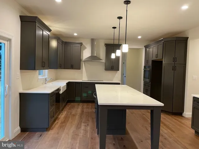 a kitchen with kitchen island a sink stainless steel appliances and cabinets