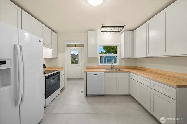 a kitchen with white cabinets and white appliances