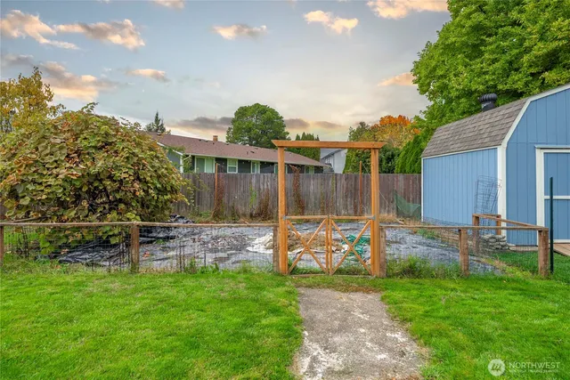 a view of a backyard with table and chairs and wooden fence