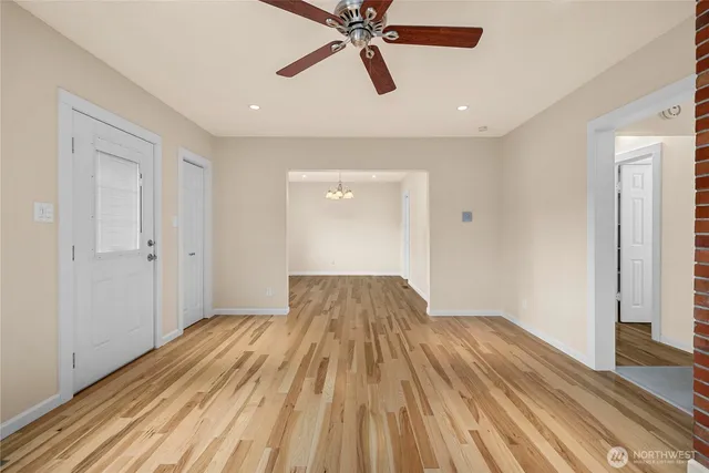 a view of a room with wooden floor and ceiling fan