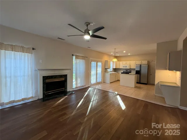 a view of a kitchen with a stove cabinets wooden floor and a fireplace