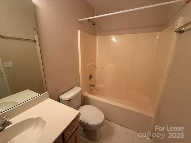 a bathroom with a granite countertop toilet sink and shower