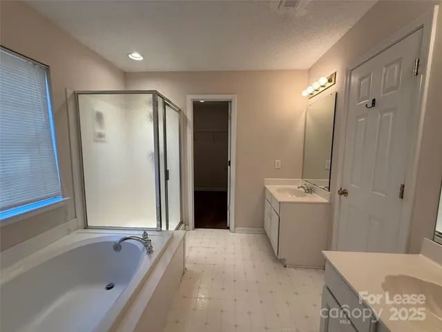 a bathroom with a tub shower and sink