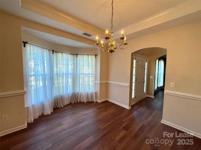 a view of a livingroom with wooden floor and a ceiling fan