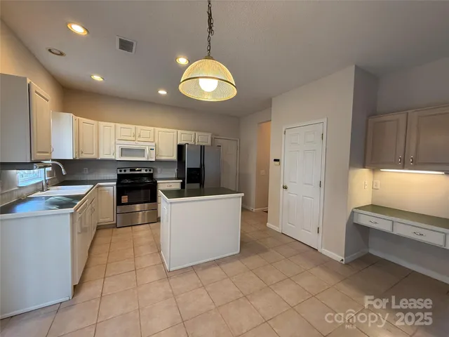 a large white kitchen with lots of counter space and appliances