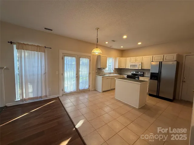 a kitchen with stainless steel appliances granite countertop a refrigerator and a stove top oven