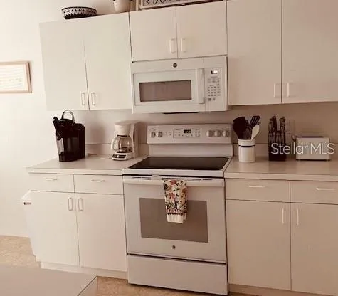 a kitchen with appliances a sink and cabinets