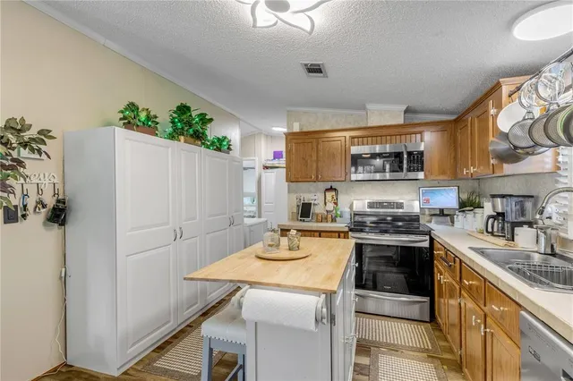 a bedroom with a large bed a flat tv screen and a chandelier