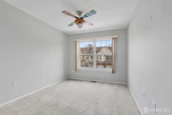 an empty room with window and ceiling fan