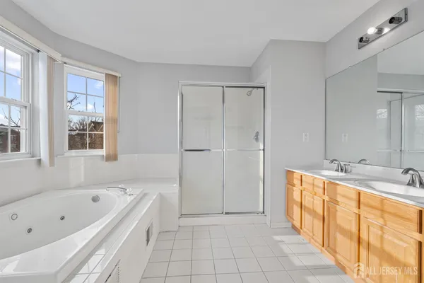 a spacious bathroom with a tub sink and mirror
