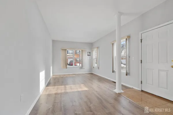 a view of a big room with wooden floor and windows