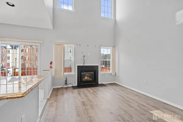a view of an empty room with a fireplace and a window