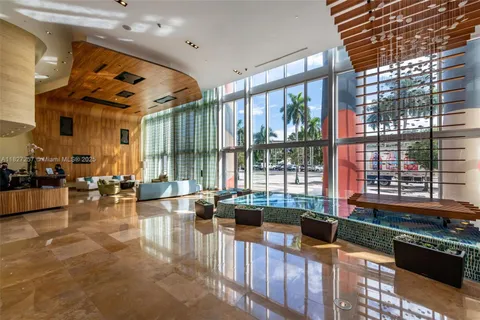 a living room filled with furniture and large windows