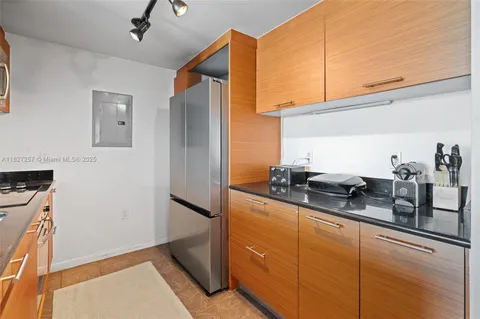 a kitchen with sink a refrigerator and cabinets