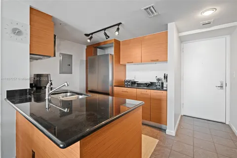 a kitchen with stainless steel appliances granite countertop a sink a stove and refrigerator